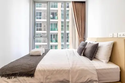a bedroom with a large bed with a large window at Hyde Sukhumvit 11 Branded Suites in Bangkok