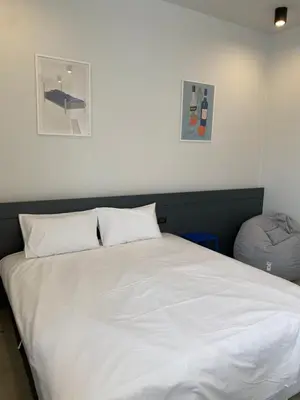 a bedroom with a white bed with two pillows at PIER 808 Hostel in Bangkok