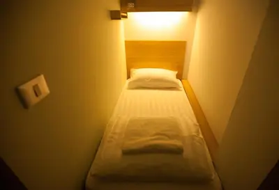 a small room with two beds in a small room at Micro Hostel in Bangkok