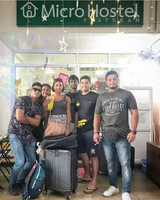 a group of people posing for a picture in a store at Micro Hostel in Bangkok