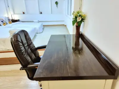 a desk with a vase of flowers on it in a room at k4 be chill *Wongwianyai BTS_80m*Family&Friend* in Godown