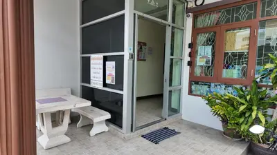 a door to a store with a bench in front at ธิติกาญจน์ อพาร์ทเม้นท์ in Ban Khlong Samrong