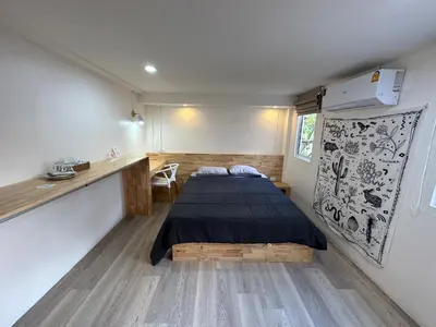 a small room with a bed and a kitchen at Letter Better Home in Bangkok