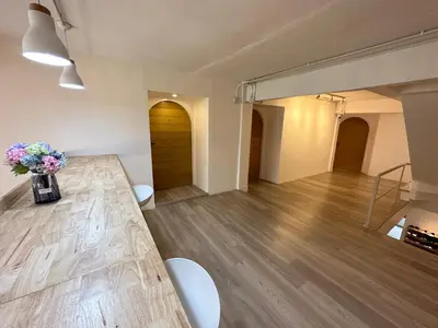 a large room with a table and flowers in a vase at Letter Better Home in Bangkok