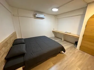 a bedroom with a bed and a desk in it at Letter Better Home in Bangkok