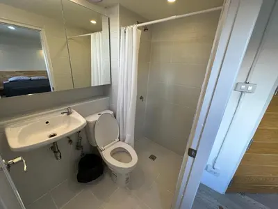 a bathroom with a sink and a toilet and a mirror at Letter Better Home in Bangkok