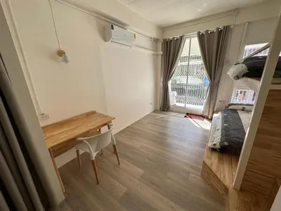 a room with a desk and a bed and a window at Letter Better Home in Bangkok