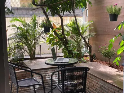 a patio with a table and chairs with a laptop on it at homey stay and cafe by hematoa in Bangkok