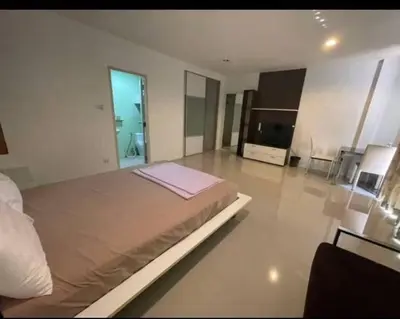 a large bedroom with a large bed and a television at BKK TEAK Hostel in Amphoe Phra Khanong