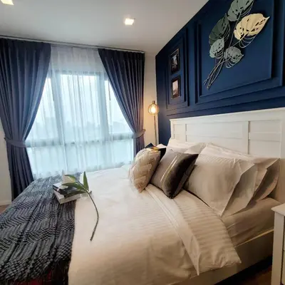 a bedroom with a large white bed with a window at KnightsBridge BTS Bearing in Ban Khlong Samrong