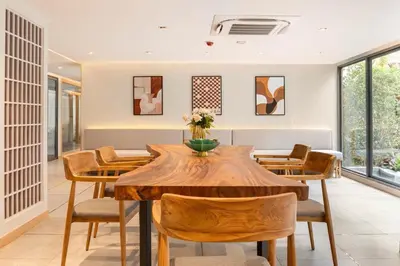 a dining room with a wooden table and chairs at Tierra Residences in Bangkok
