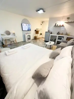 a large white bed in a living room with a couch at NK hostel 31 in Ban Bang Phang