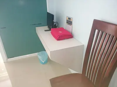 a desk with a red bag on it next to a chair at IsYou Sabye ห้องพักรายวัน รามคำแหง in Ban Zong Katiam