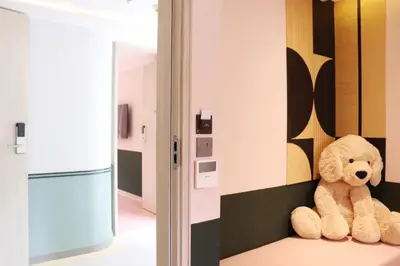 a teddy bear sitting on a shelf in a kitchen at The Quarter Ratchathewi by UHG in Bangkok