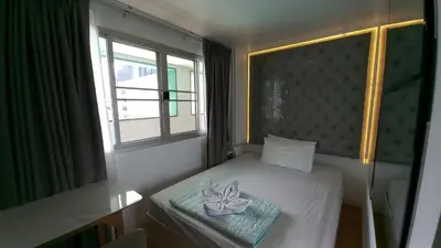 a small bedroom with a bed with a flower on it at Silom Cityview Paradise Room in Bang Rak