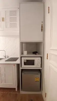 a kitchen with a white cabinet and a microwave at Silom Cityview Paradise Room in Bang Rak