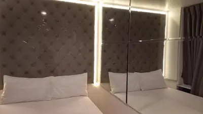 a bedroom with a large headboard and white pillows at Silom Cityview Paradise Room in Bang Rak