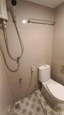 a bathroom with a toilet and a shower at Silom Cityview Paradise Room in Bang Rak