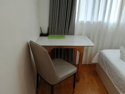 a desk with a chair in a room with a bed at Silom Cityview Paradise Room in Bang Rak