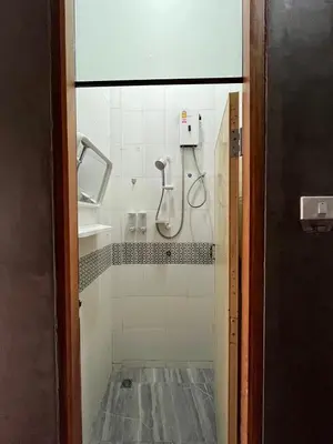 a shower in a bathroom with a glass door at Rotinis Hostel in Pom Prap