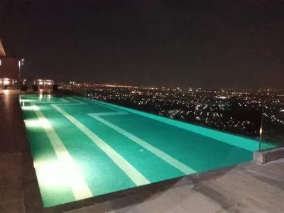 a swimming pool at night with a city at Near central westgate at bangyai 80 in Ban Bang Krabu
