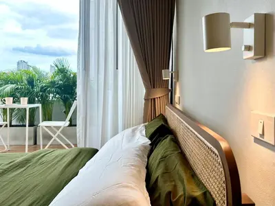 a bed in a room with a large window at The Tangerine Guesthouse in Bangkok