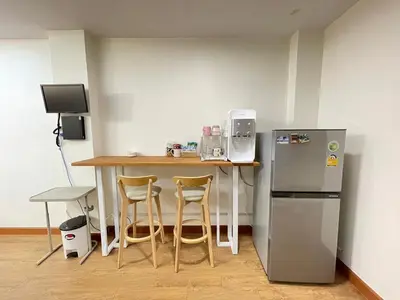 a kitchen with a table and a refrigerator at Modern 5-Bedroom Townhome near MRT and Local Charm in Bangkok