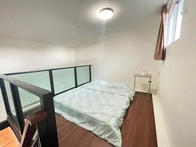 a small bedroom with a bed and a window at Modern 5-Bedroom Townhome near MRT and Local Charm in Bangkok