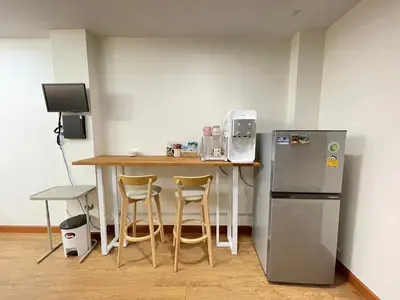 a kitchen with a table and a refrigerator at Modern 5-Bedroom Townhome near MRT and Local Charm in Bangkok