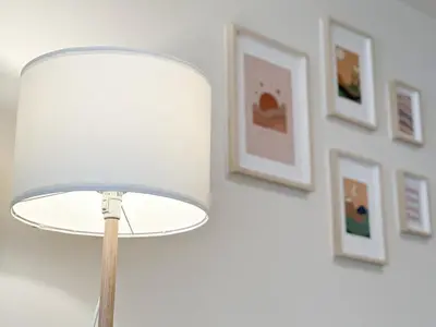 a lamp in a room with pictures on the wall at Happiness sleep C3 in Ban Bang Phang