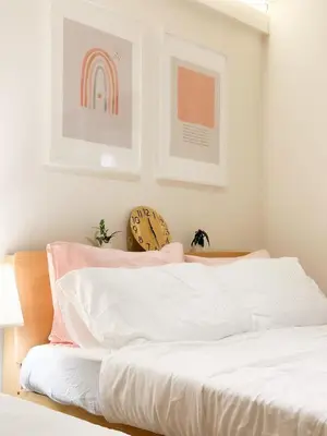 a bed with white sheets and a rainbow on the wall at Happiness sleep C3 in Ban Bang Phang