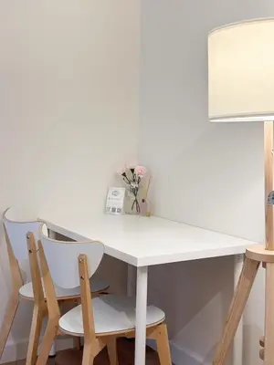 a white table with two chairs and a vase of flowers at Happiness sleep C3 in Ban Bang Phang