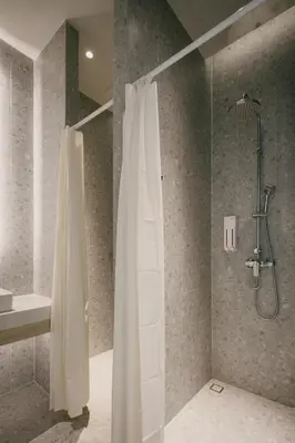 a bathroom with a shower with a shower curtain at Matini Hostel grandstation in Bangkok