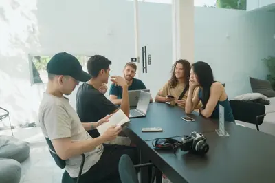 a group of people sitting around a table at Matini Hostel grandstation in Bangkok
