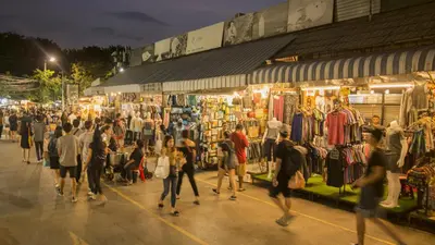 a crowd of people walking around a market at night at Matini Hostel grandstation in Bangkok