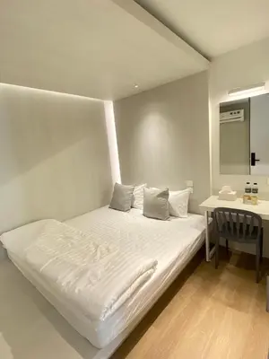a white bed in a room with a desk at Matini Hostel grandstation in Bangkok