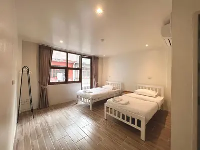 a bedroom with two beds and a large window at Krung Tone Hostel in Bangkok