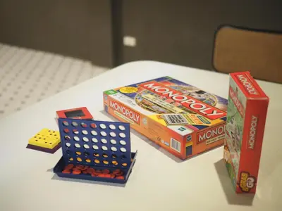a table with two boxes of dominoes and a box of chips at Krung Tone Hostel in Bangkok