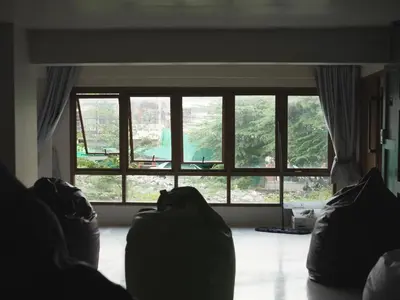 a living room with a large window with a view at Krung Tone Hostel in Bangkok