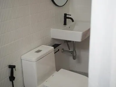 a bathroom with a white toilet and a sink at Krung Tone Hostel in Bangkok