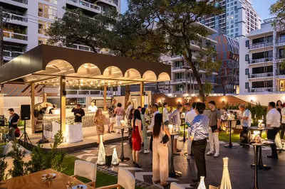 a group of people standing in a courtyard in a city at Floral Court Hotel & Residence Sukhumvit 13 in Bangkok