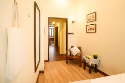 a room with a chair and a table and a hallway at Niras Bankoc Hostel in Bangkok