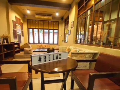 a living room with a table with a relax sign on it at Niras Bankoc Hostel in Bangkok