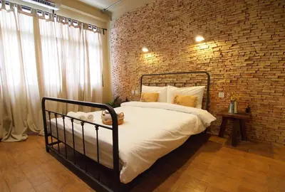 a bedroom with a brick wall and a bed at Niras Bankoc Hostel in Bangkok