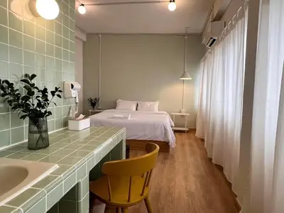 a bedroom with a bed and a sink and a desk at La Moon House in Salaya