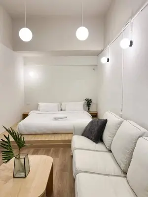 a bedroom with a bed and a white couch at La Moon House in Salaya
