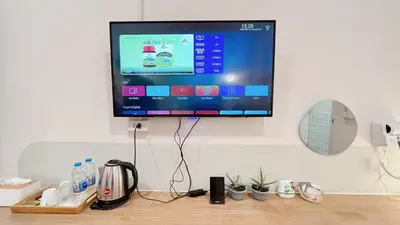 a flat screen tv hanging on a wall at La Moon House in Salaya