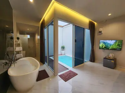a bathroom with a tub and a swimming pool at KVILLA in Ban Khlong Bang Chak