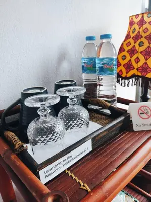 a tray with glass dishes on a table with water bottles at mstay in Bangkok