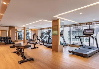 a gym with several treadmills and exercise bikes at SAMALA Hotel Bangkok in Bangkok